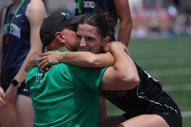 Clear Fork's Taylor Bly hugs her father and assistant coach after being presented with the Division III regional championship medal in the 400-meter dash on Saturday, May 30, 2026 at Piqua High School.