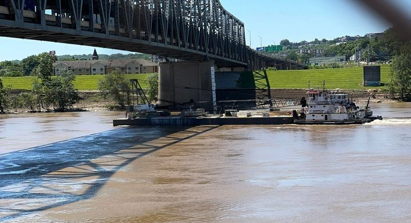 The Florence T tugboat pushes a barge with a crane under the Brent Spence Bridge to a construction staging area near Covington.