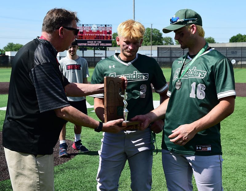 Central Catholic's Dylan Minnie, center, and Luke Spitler accept the Division IV regional runner-up trophy from Ed Rehfus, on Thursday.