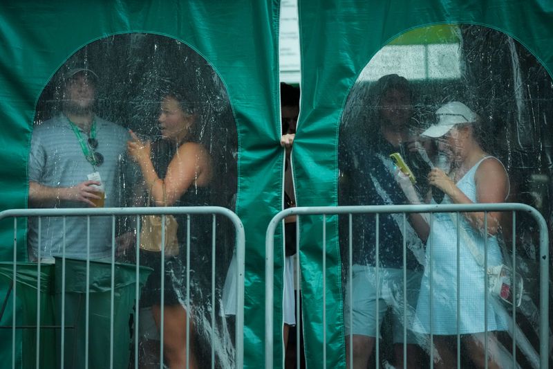 Patrons take cover during a weather delay during the third round of the Memorial Tournament at Muirfield Village Golf Club on June 6, 2026. Lightning and rain stopped play.