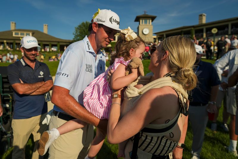 J.T. Poston hands his daughter, Katherine “Scottie” Poston, to his wife, Kelly, following his win at the 2026 Memorial Tournament.