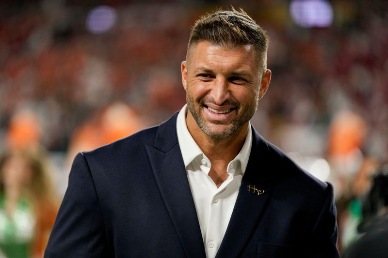Tim Tebow stands on the sidelines ahead of the College Football Playoff National Championship between Indiana and Miami (Florida), Monday, Jan. 19 2026, in Miami Gardens.