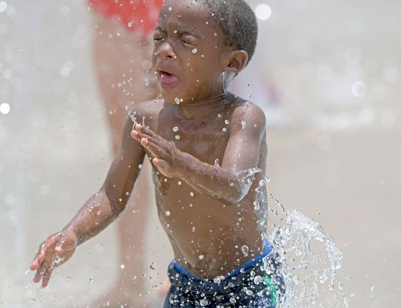 Katier Anderson, 3 years old of North Carolina, cools off from the heat while visiting the area Wednesday afternoon at the Ontario Spray Park at Marshall Park.