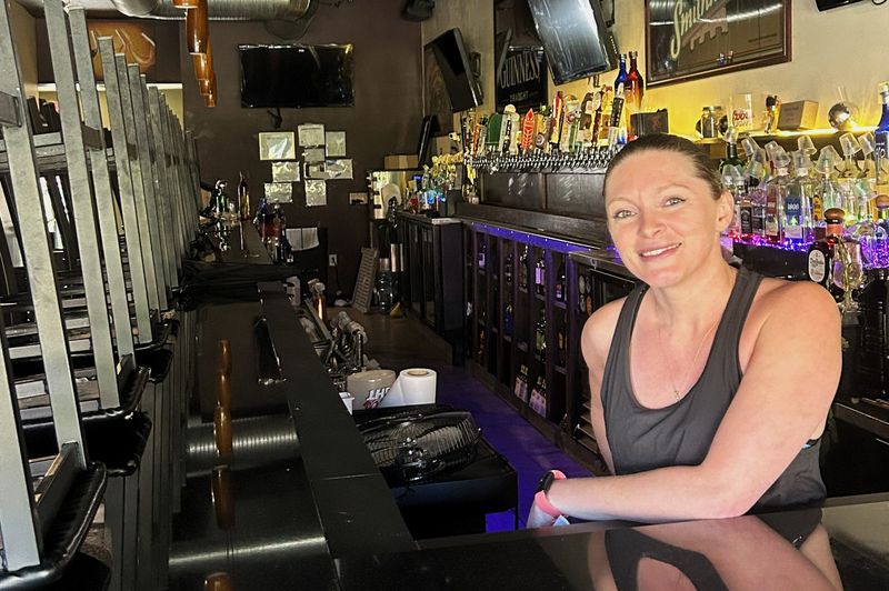 Jess Williams stands at the bar of the Highland Tavern, which she owns and recently decided to close on Fridays and Saturdays following mounting pressure from the city and days after a shooting in Highland Square on June 7.