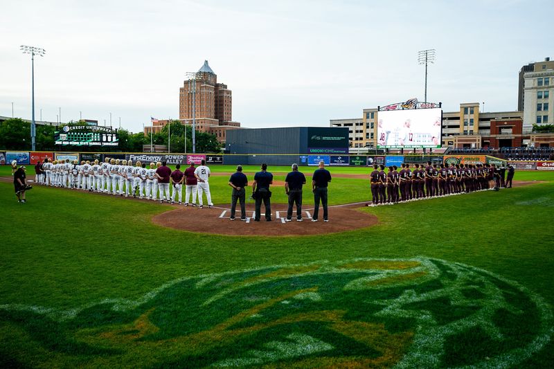 High school baseball players from New Albany, left, and Walsh Jesuit, right, take in the playing of the national anthem before an OHSAA DII state final baseball game, June 13, 2026, at Credit Union Park in Akron, Ohio.