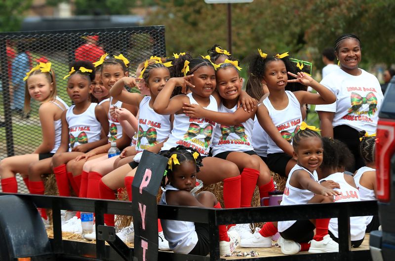 Wolf Pack cheerleaders enjoy their ride Saturday, June 20, 2026, in the Alliance Juneteenth Parade. The youngsters rode alone with a sign reading "PYT," which is a Michael Jackson song that means "Pretty Young Thing."