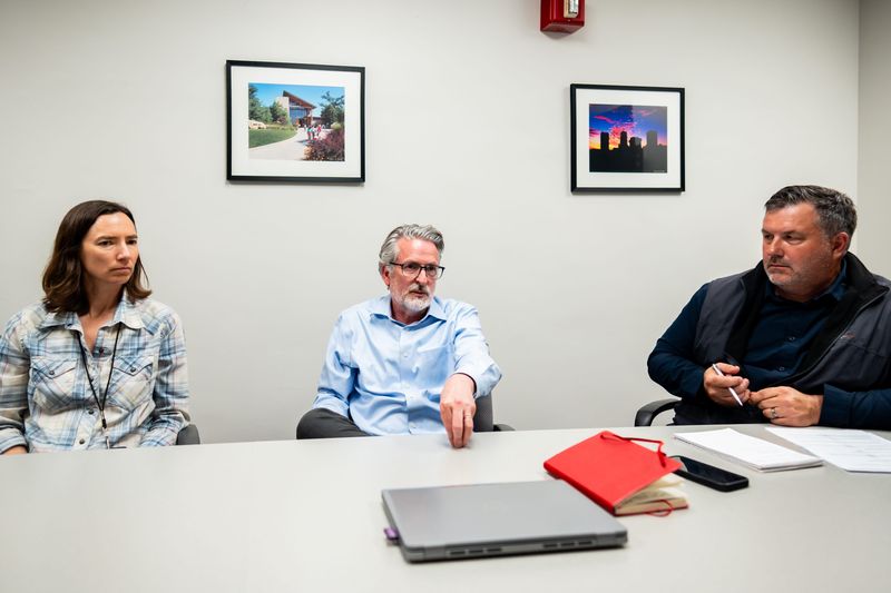 Emily Collins, environmental services manager for the Akron Public Service Department, left, Kyle Julien, planning director, and Jeff Bronowski, deputy service director, discuss potential changes to zoning rules regarding data centers at Akron City Hall.