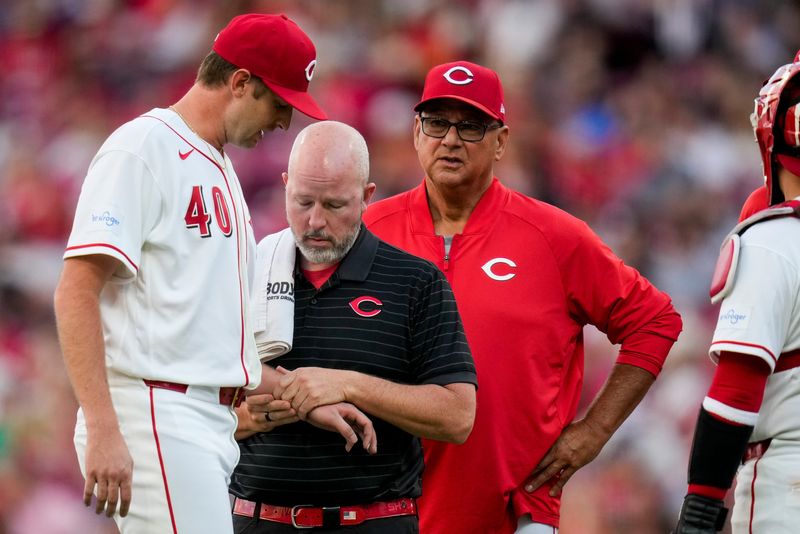 Cincinnati Reds pitcher Nick Lodolo (40) is examined by a trainer after being hit by a line drive in the fourth inning of the MLB National League Central game between the Cincinnati Reds and the Milwaukee Brewers at Great American Ball Park in downtown Cincinnati on Tuesday, June 23, 2026.
