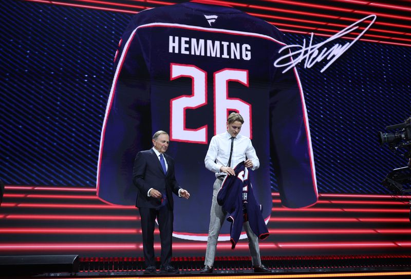 Oscar Hemming reacts beside NHL commissioner Gary Bettman after being selected with the fourteenth pick in the first round of the 2026 NHL Draft by the Columbus Blue Jackets at KeyBank Center in Buffalo, New York, on Friday, June 26, 2026.