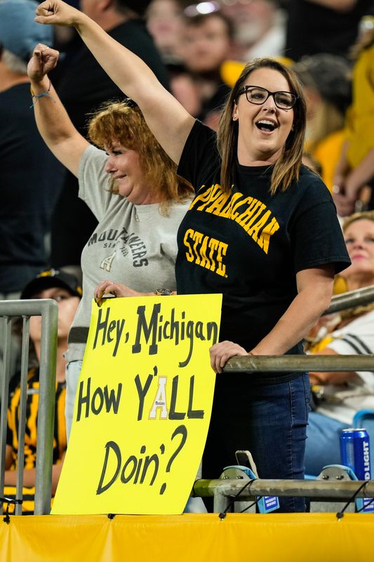 Sep 2, 2021; Charlotte, North Carolina, USA; Appalachian State Mountaineers fan holds her sign with message to Michigan on it during the second half against the East Carolina Pirates at Bank of America Stadium. Mandatory Credit: Jim Dedmon-USA TODAY Sports