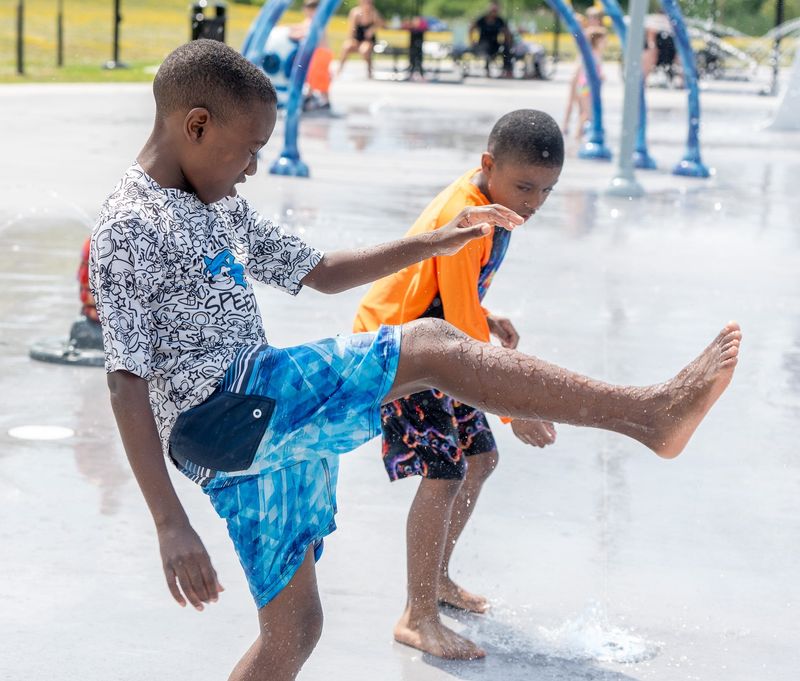 Bryce Williams, 9, of Streetsboro, kicks through a water sprout with his cousin, Leiland Hayes, 8, of Debary Florida at Streetsboro City Center Splash Park on June 29, 2026.