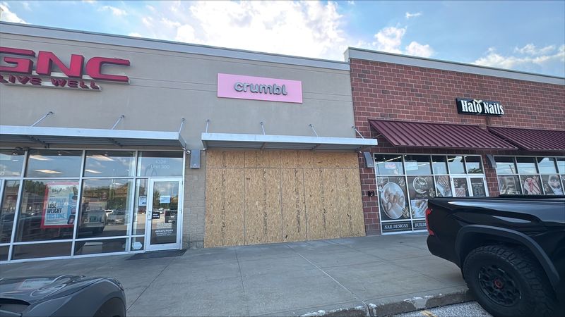 Temporary boards cover the storefront June 29 at Crumbl Cookies on Kent Road in Stow after a driver smashed into the shop.