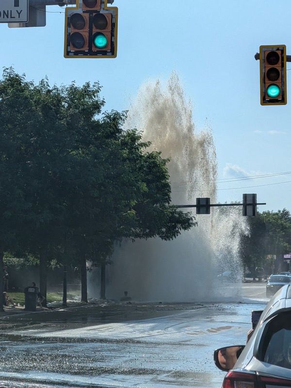 A ruptured water line gushes June 29 on West Market Street near the I Promise School and a Circle K station in Akron.