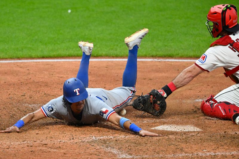 Jun 29, 2026; Cleveland, Ohio, USA; Texas Rangers shortstop Nicky Lopez (33) scores beside Cleveland Guardians catcher Austin Hedges (27) in the seventh inning at Progressive Field. Mandatory Credit: David Richard-Imagn Images