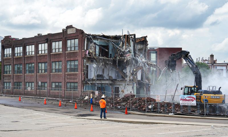 A worker watches as ProQuality Demolition tears down the 113-year-old Lincoln Building on July 7. The University of Akron is demolishing the building to make way for a new polymer facility.