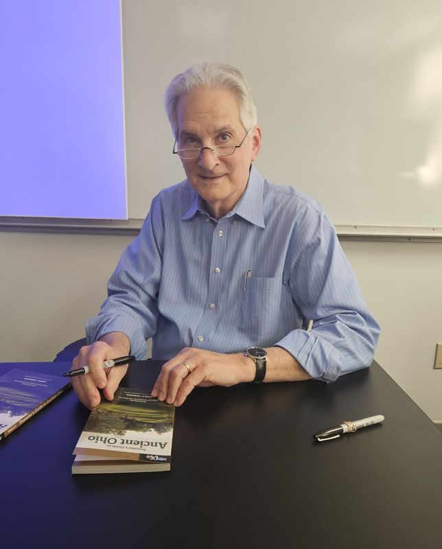 John Hancock signs his travel guidebook, which features information for those traveling around Southern Ohio looking for Native American mounds.