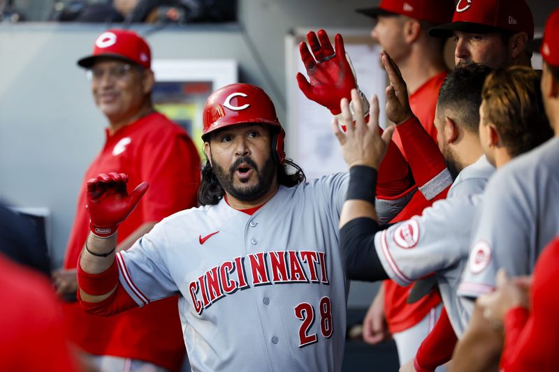 Cincinnati Reds third baseman Eugenio SuÃ¡rez (28) high-fives teammates in the dugout after hitting a solo-home run against the Seattle Mariners during the fourth inning at T-Mobile Park.