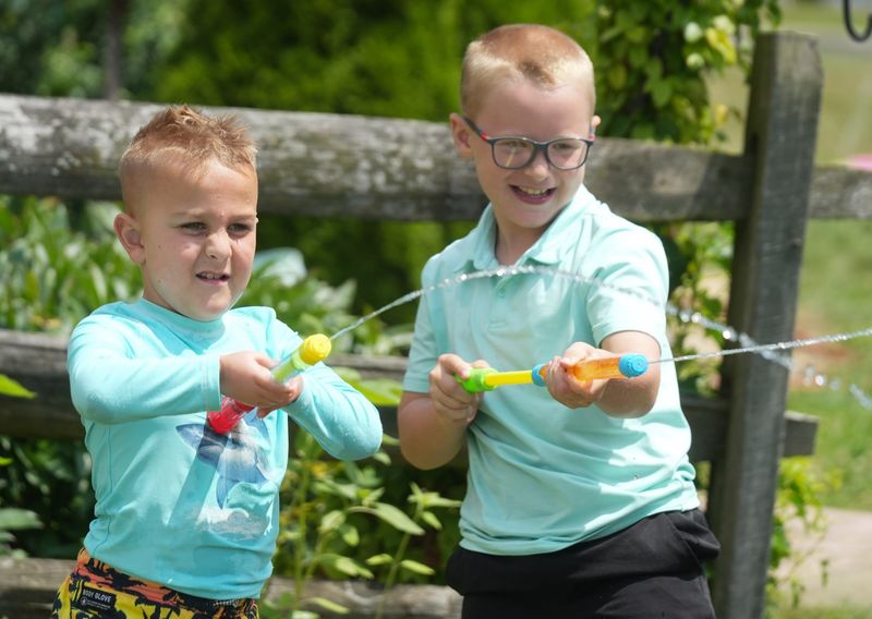 Beau Smith, 7, left, and Silas Smith ,8, spray water guns in the “Cup Race” at the Stark Library Lake Community Branch's recent “Splish Splash Bash.”