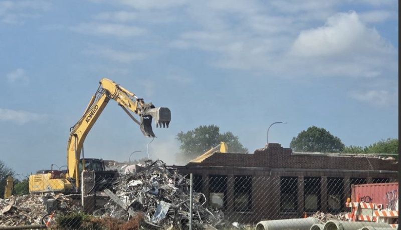 Demolition crews knock down the final front wall of the former Gahanna Lincoln High School on July 8, 2026, as seen from Havens Corners Road near the intersection of North Hamilton Road.