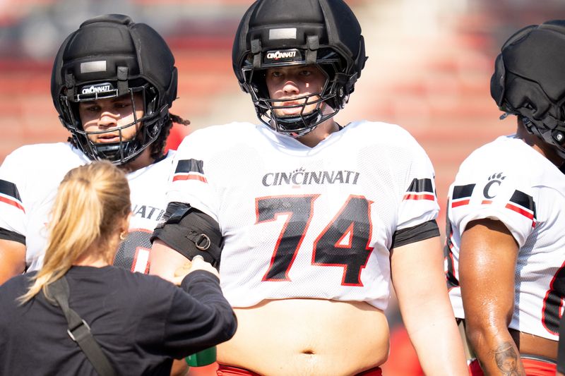6-foot-6, 320-pound Joe Cotton takes a water break in between drills at Nippert Stadium during Cincinnati Bearcats training camp.