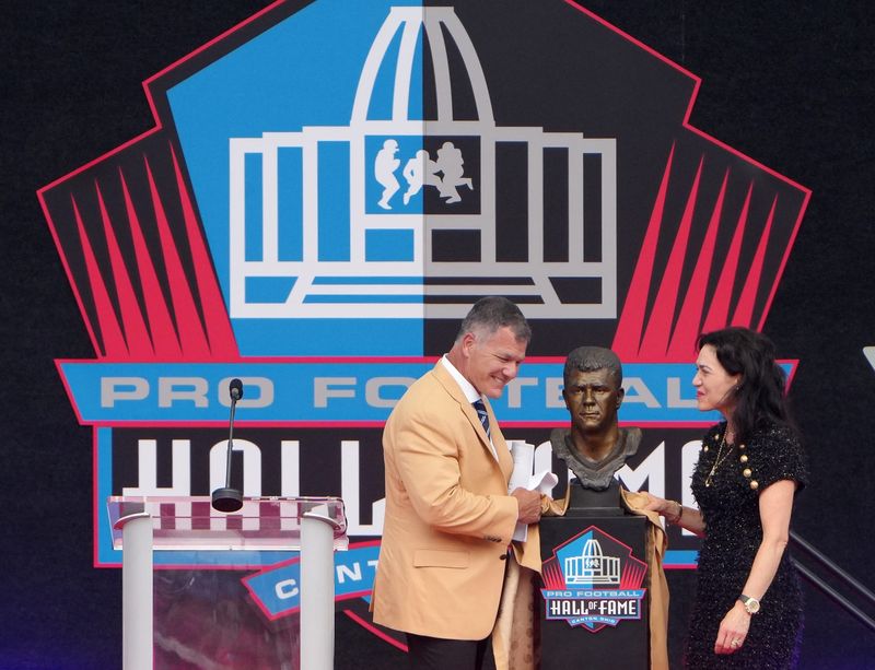 Adam Vinatieri and Indianapolis Colts owner Carlie Irsay-Gordon unveil Vinatieri’s bust at the 2026 Pro Football Hall of Fame Enshrinement in Canton on Aug. 8, 2026.
