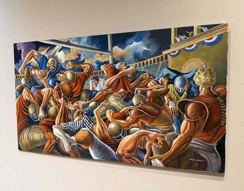 This painting by late acclaimed artist Ernie Barnes depicts the violence of professional football. Barnes was a former NFL player whose paintings were acclaimed and known in pop culture.