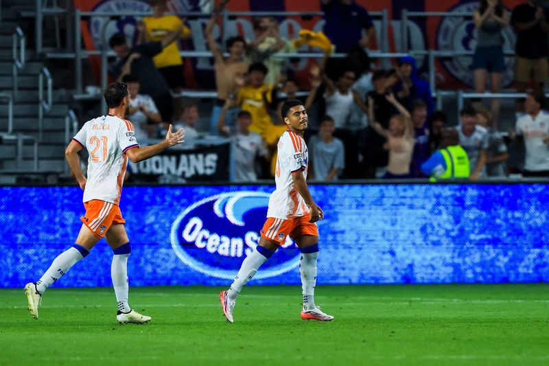Cincinnati forward Evander, right,  reacts after scoring a goal in the first half against Atlas FC during the Leagues Cup Phase One match at TQL Stadium Tuesday, Aug. 11. Matt Miazga looks to congratulate Evander.