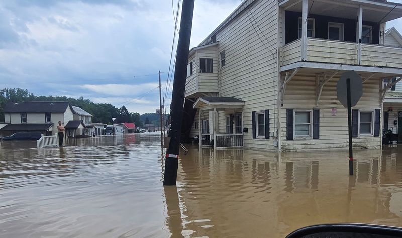 A man stands amid the high water in Crooksville on Tuesday, August 12, 2026 after high water caused extensive damage in the area. The Ohio National Guard was called out to the Perry County community.