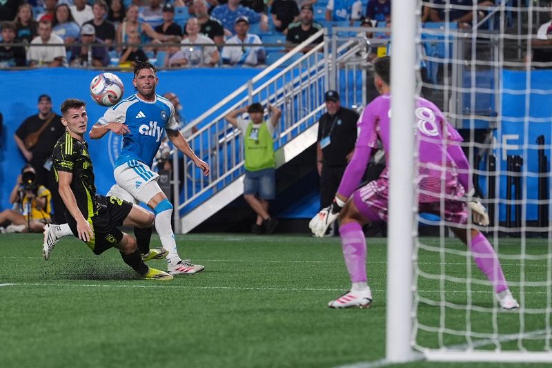 Aug 15, 2026; Charlotte, North Carolina, USA;  Columbus Crew goalkeeper Patrick Schulte (28) dives for the ball  from the goal shot by Charlotte FC midfield Brandt Bronico (13) during the first half at Bank of America Stadium. Mandatory Credit: Jim Dedmon-Imagn Images
