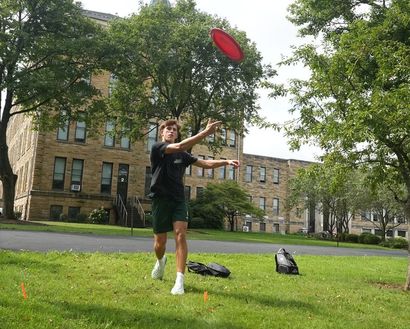 Griffen Rohr, a senior at Central Catholic High School and member of the Central Catholic Disc Golf Club, throws a drive at the new course on the school campus in Perry Township.