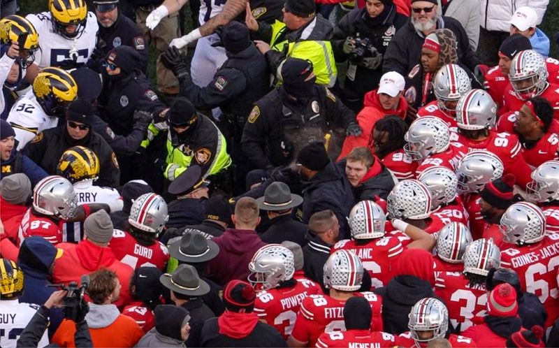 A University of Michigan police officer deploys pepper spray as Michigan and Ohio State players fight following their game on Nov. 30, 2024. Michigan won 13-10.