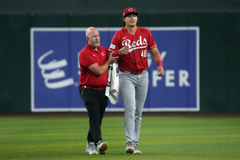 Reds left fielder Michael Toglia leaves with the trainer after suffering a dislocated right shoulder diving for a ball in the first inning against the Arizona Diamondbacks at Chase Field Friday, Aug. 21.