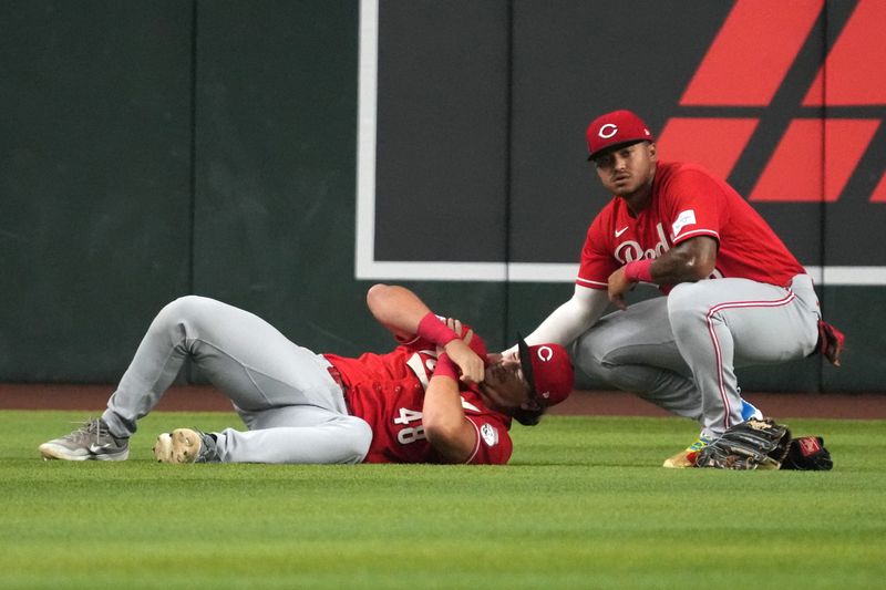 Reds center fielder Dane Myers tends to left fielder Michael Toglia, who suffered a dislocated shoulder on a diving catch in the first inning of the first game of the series against the Diamondbacks in Arizona on Friday, Aug. 21.