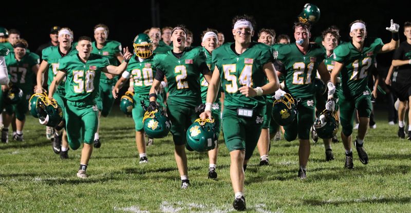 Newark Catholic's Jack Gossett (54) and Landon Cox (2) lead the Green Wave in celebration following their 28-27 victory in overtime against visiting Huntington on Aug. 21, 2026.