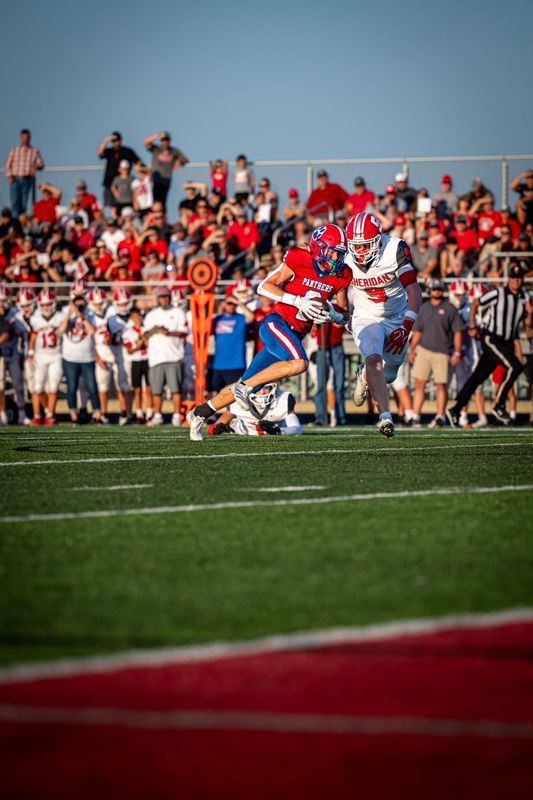 Licking Valley's Brandt Lichtenauer runs after the catch with Sheridan's Connor Roshon in pursuit during the host Panthers' 28-13 victory at Randy Baughman Stadium on Aug. 21, 2026.