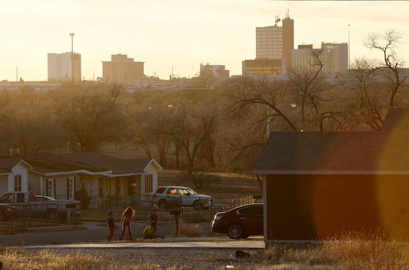 Children play along Martin Luther King Jr Blvd. with the downtown Lubbock skyline, as seen on Thursday, Jan. 5, 2023.