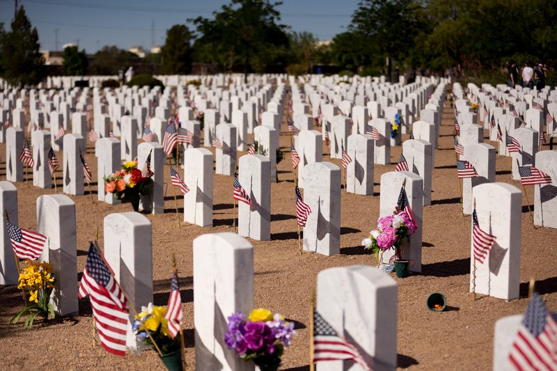 Scouts of America and Girl Scouts troops place flags on the graves at Fort Bliss Cemetery before Memorial Day on Saturday, May 25, 2024.