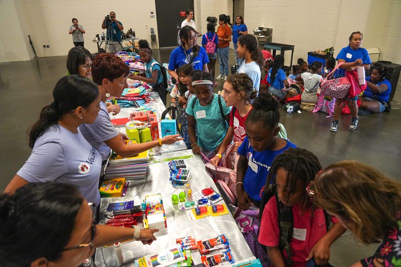 Children with Big Brothers Big Sisters of Central Texas line up to get backpacks and school supplies at a City of Austin city-wide school supply drive at the Palmer Events Center on Friday, July 26, 2024. Austin residents were invited to drop off backpacks and school supplies at the Palmer Events Center where city employees and volunteers collected and sorted the supplies that would then be taken to schools in the Austin Independent School District.