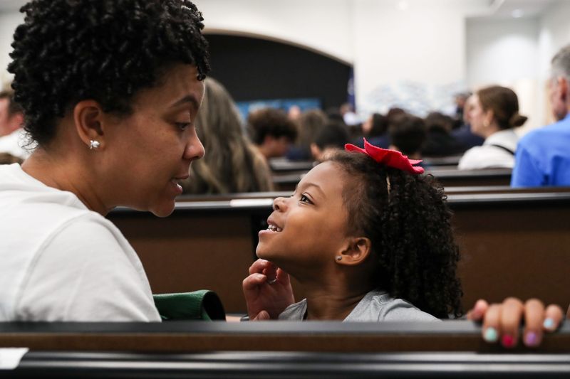 Ava looks to mother Roslyn Ross while waiting for a ribbon cutting ceremony to start at the Creekside Elementary School campus on Wednesday, July 31, 2024, in Corpus Christi, Texas. Ava will be starting pre-k four with her brother and sister at the new school.