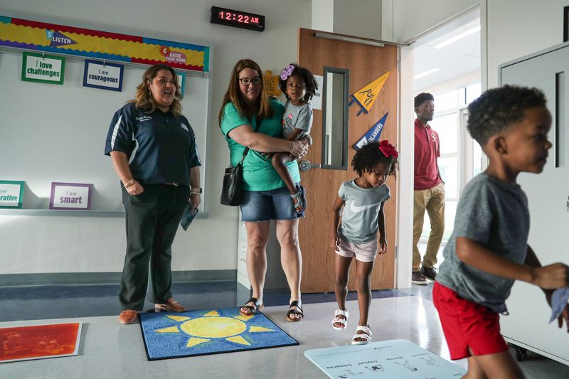 Patricia De Leon, a school counselor at the new Creekside Elementary School, welcomes Kayla Warren, holding Stella Ross and siblings Ava and Marcelus Jr., to her new classroom on July 31, 2024, in Corpus Christi.