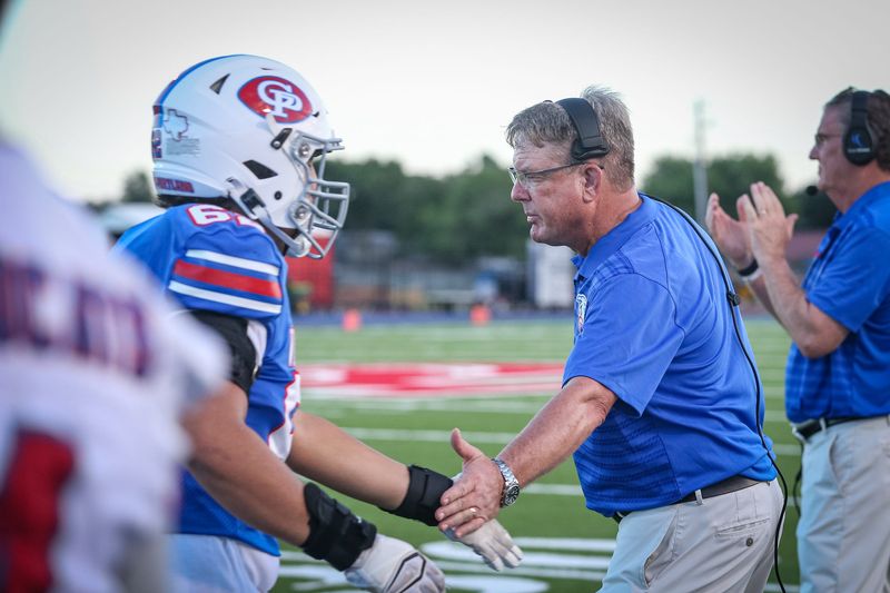 Gregory-Portland head football coach Brent Davis high-fives Josiah Ramirez as he comes in off the field during Friday's game at Ray Akins Wildcat Stadium, Sept. 20, 2024, in Portland, Texas.
