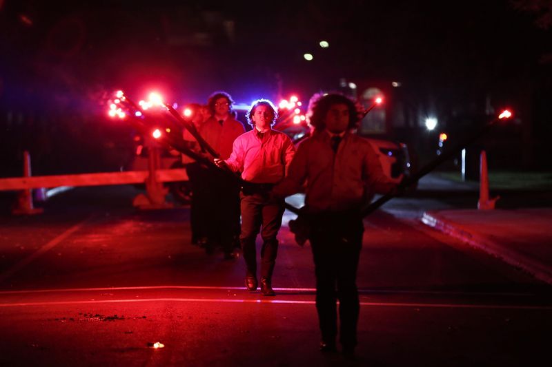 Saddle Tramps members carry red flares down Memorial Circle on the Texas Tech University campus during the 66th annual Carol of Lights on Dec. 8, 2024 in Lubbock, Texas.