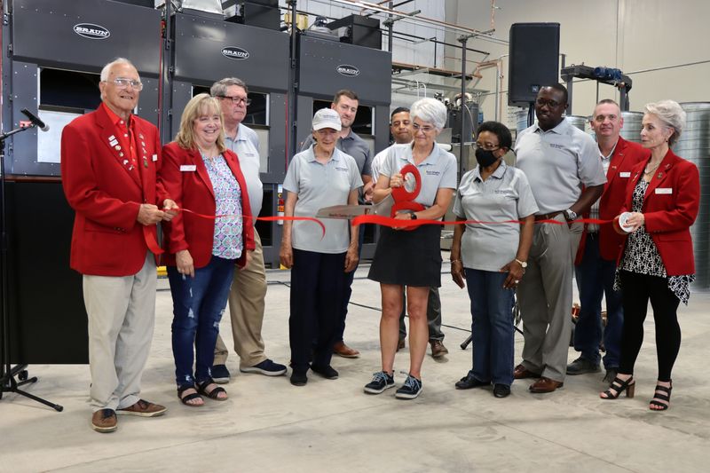In this July 2021 file photo, Puff Niegos, president of the North Heights Linen Service, LLC Board of Directors, cuts the ribbon with other members of the board and members of the Amarillo Chamber of Commerce during a ribbon cutting ceremony. The facility has been sold to a Canada-based company.