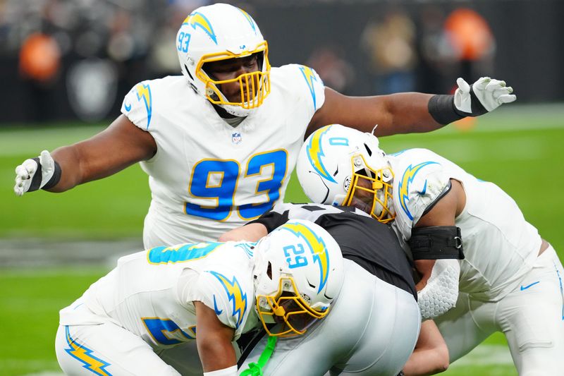 Las Vegas Raiders tight end Michael Mayer (87) is tackled by the Los Angeles Chargers' Tarheeb Still (29), Daiyan Henley (0), and Otito Ogbonnia (93).