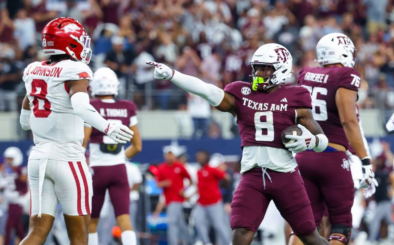 Sep 28, 2024; Arlington, Texas, USA; Texas A&M Aggies running back Le'Veon Moss (8) reacts in front of Arkansas Razorbacks defensive back Jayden Johnson (8) during the second half at AT&T Stadium. Mandatory Credit: Kevin Jairaj-Imagn Images