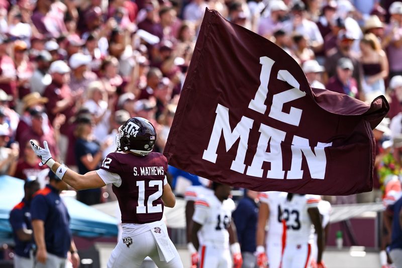Sep 23, 2023; College Station, Texas, USA; Texas A&M Aggies linebacker Sam Mathews (12) waves the 12th Man flag during pre-game runout against the Auburn Tigers at Kyle Field. Mandatory Credit: Maria Lysaker-USA TODAY Sports
