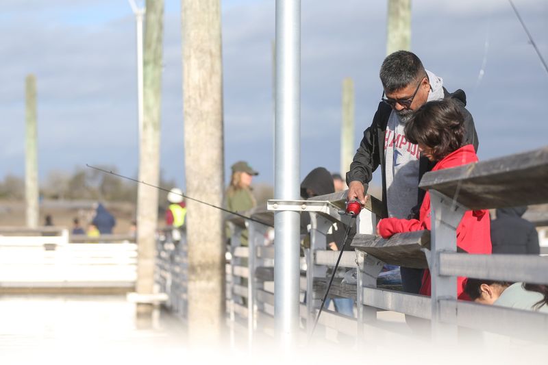 Joe Hernandez helps his daughter, Lily Hernandez, fish at the 33rd annual Kid Fish event at Lake Corpus Christi State Park in Mathis on Jan. 25, 2025.