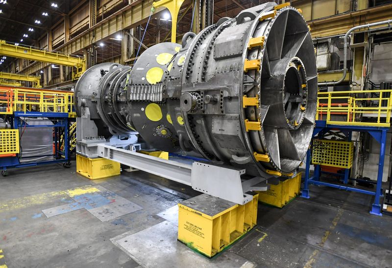 A gas turbine near a United States flag at the GE Vernova plant in Greenville, S.C. Thursday, January 30, 2025.