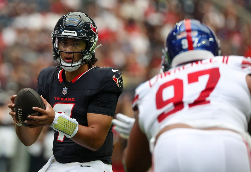 Aug 17, 2024; Houston, Texas, USA; Houston Texans quarterback C.J. Stroud (7) drops back to pass against New York Giants defensive tackle Dexter Lawrence II (97) in the first quarter at NRG Stadium. Mandatory Credit: Thomas Shea-USA TODAY Sports