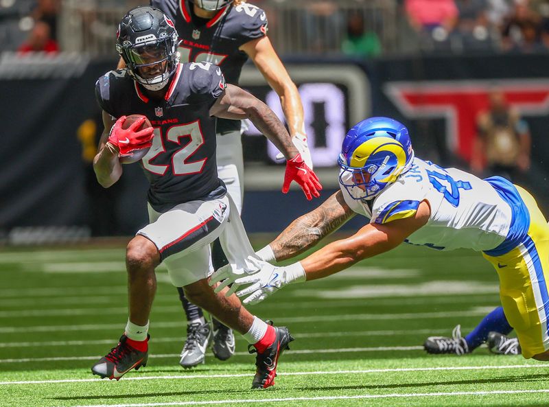 Aug 24, 2024; Houston, Texas, USA; Houston Texans running back Cam Akers (22) rushes against Los Angeles Rams linebacker Brennan Jackson (44) in the first quarter at NRG Stadium. Mandatory Credit: Thomas Shea-USA TODAY Sports